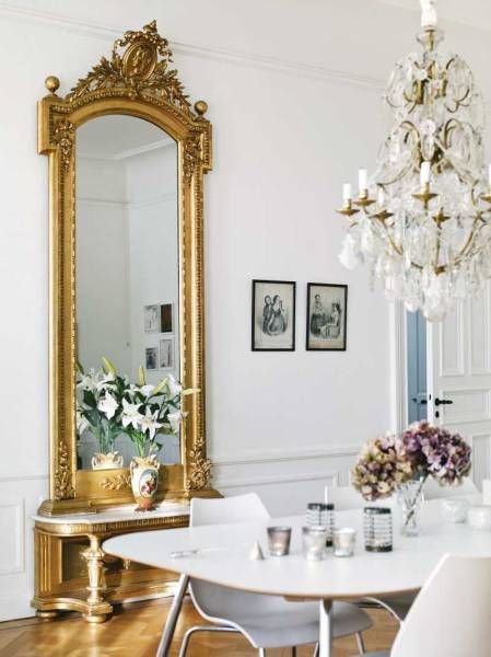beautiful antique gold mirror in a white dining room